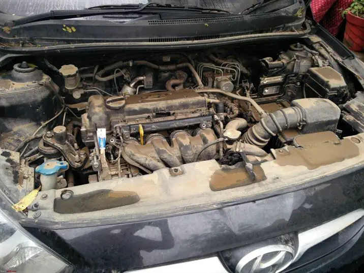 Hombre revisando el motor de un coche clásico